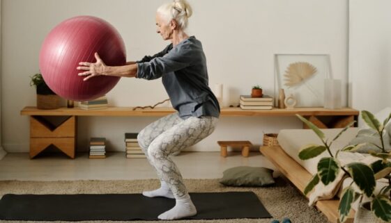 aged-woman-doing-squats-with-fitball-2024-01-10-23-35-04-utc-2