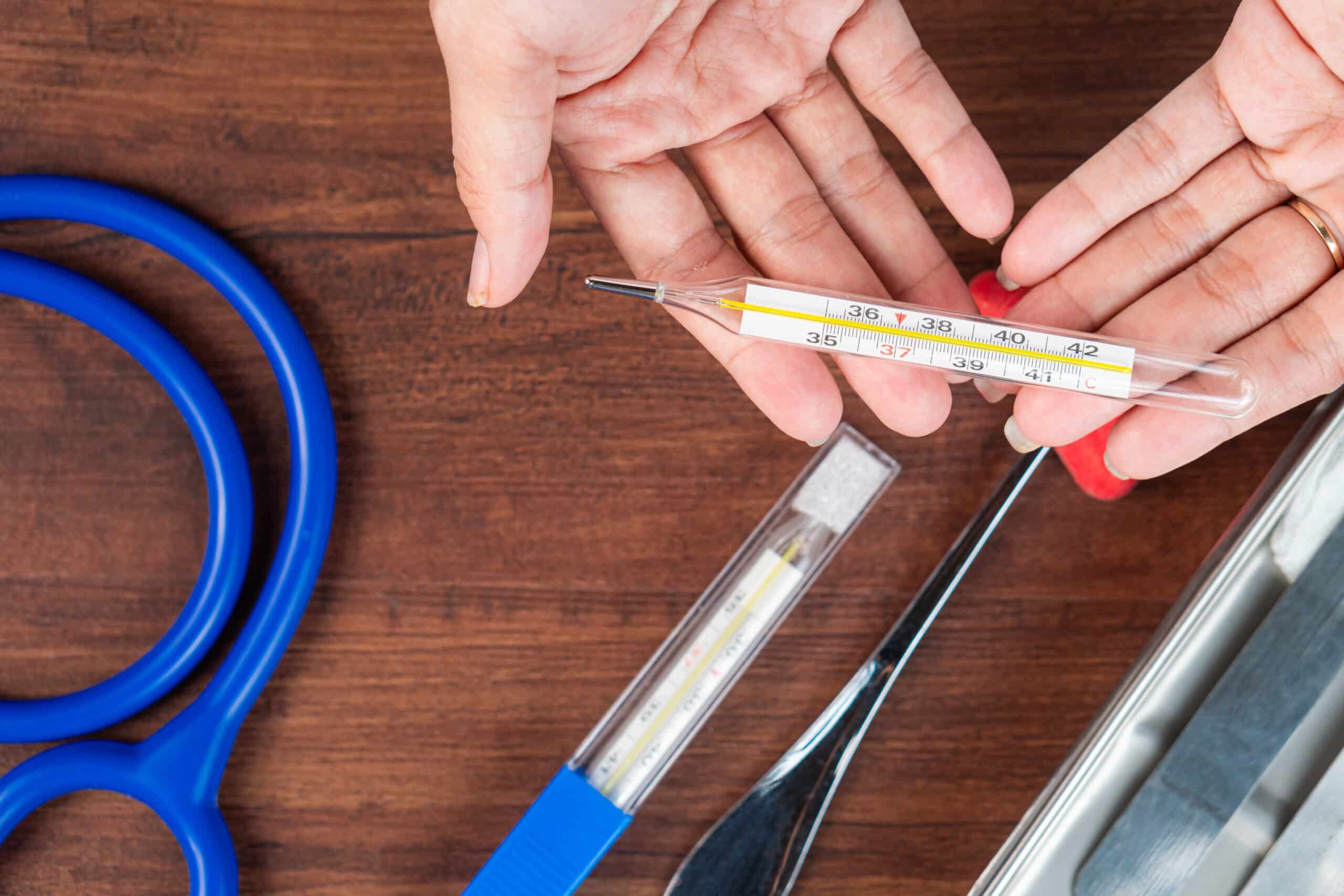 Hands Exchanging a Thermometer in a Medical Setting