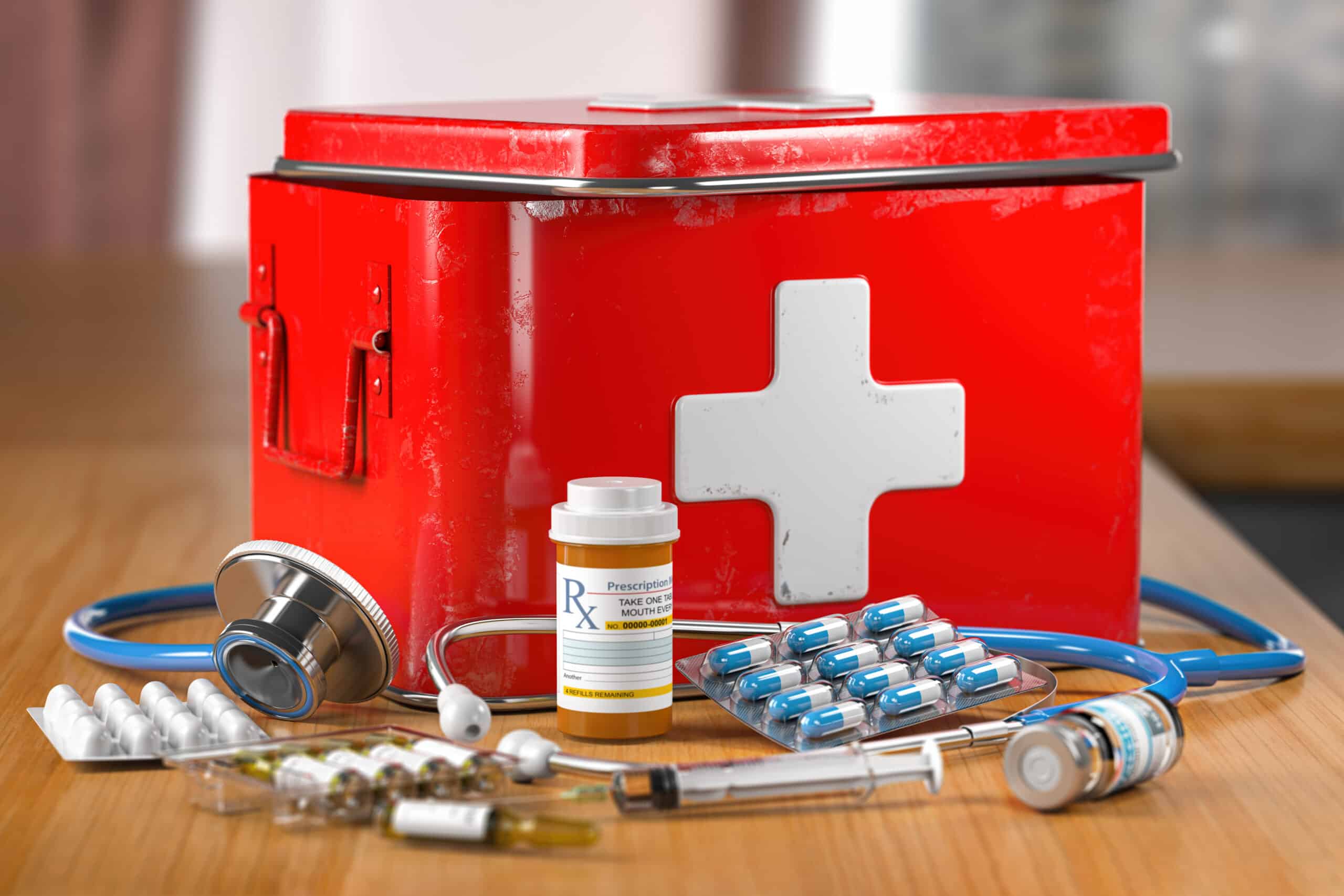 Open first aid kit with stethoscope, pills and smedicationon the