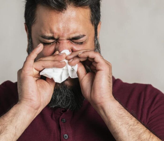 Sick Indian man blowing his nose
